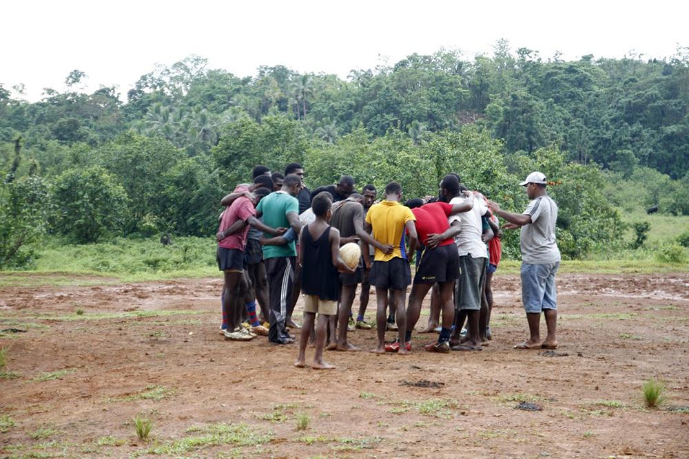 Caption: Village boys gather for a pre-training huddle and prayer (February 2016)